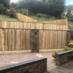 Feather edge fencing between brick pillars