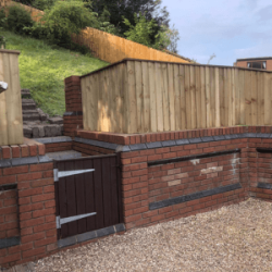 Feather edge fencing on top of brick wall