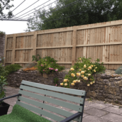 Old wall with feather edge fencing on top of it